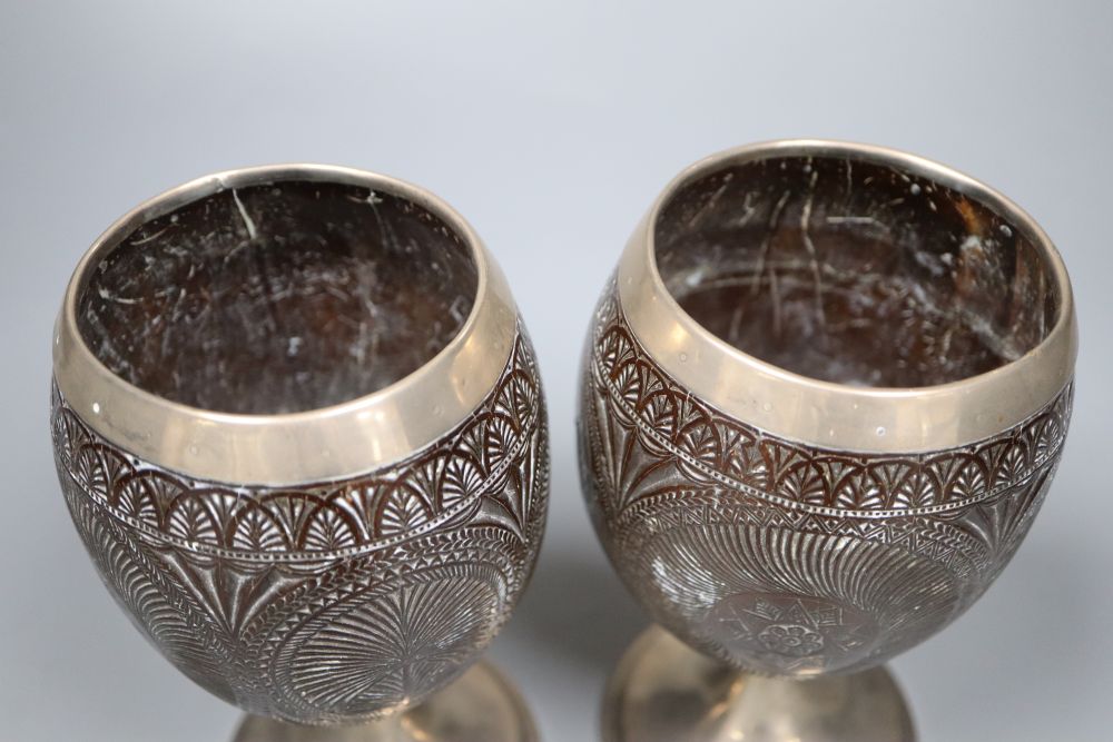 A pair of 19th century white metal mounted coconut cups, indistinct marks, 16.6cm.